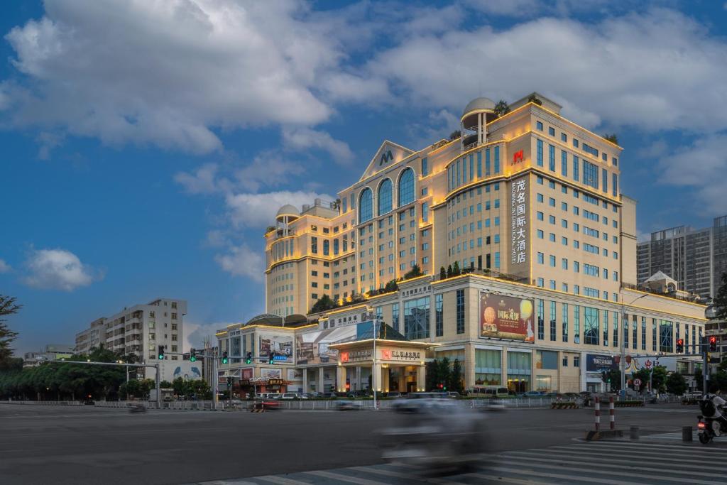 a large building on a street in a city at Maoming International Hotel in Maoming