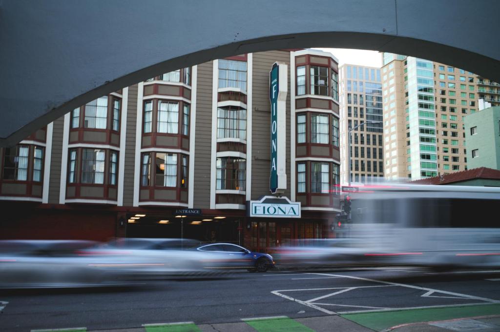 a car driving past a building with a sign that says wow at Hotel Fiona in San Francisco