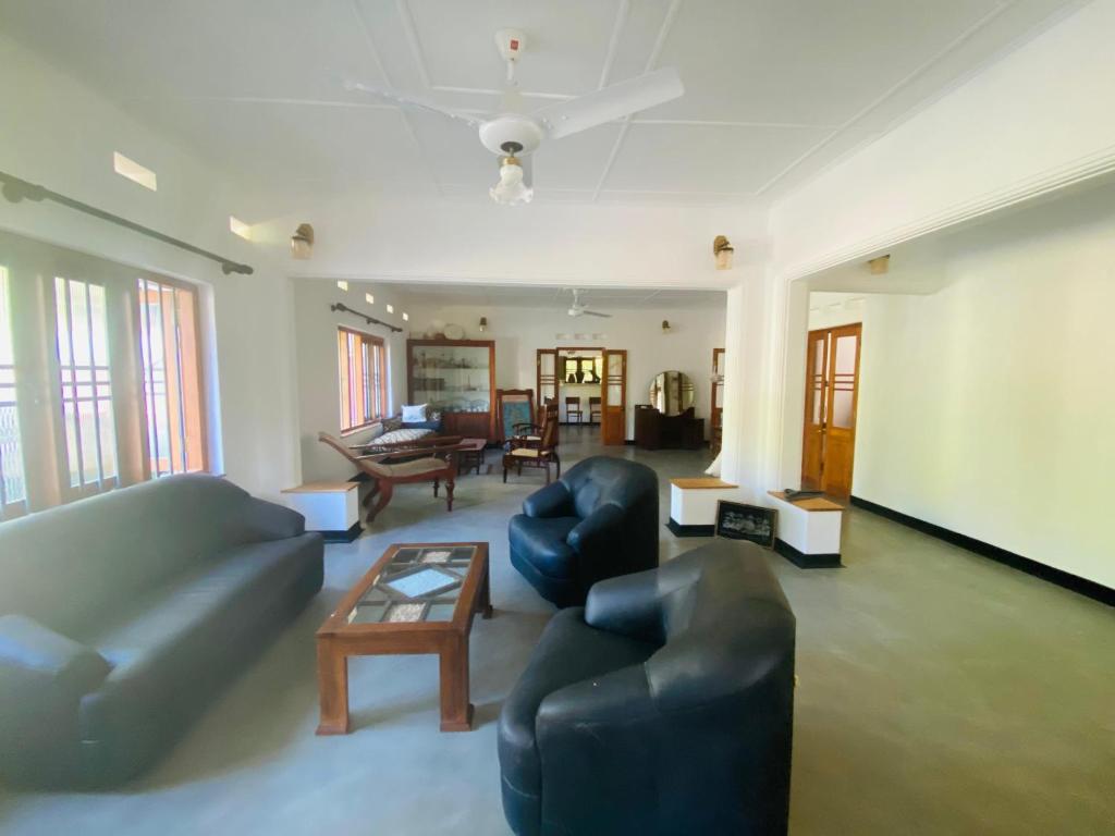 a living room with two couches and a table at Happy Valley Residence Unawatuna in Galle