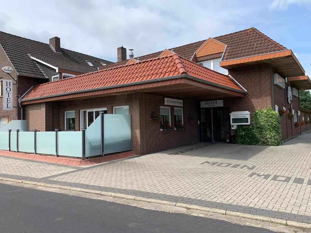 une maison en briques avec une allée en face de celle-ci dans l'établissement Hotel Stubbe, à Papenbourg