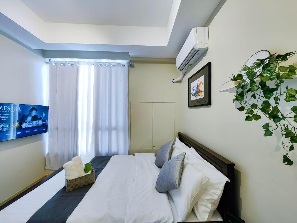 馬尼拉的住宿－Condotel at Sunshine100 Mandaluyong City near EDSA，卧室配有白色的床和窗户。