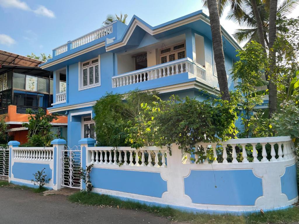 a blue house with a white fence in front of it at Sai Homestay Goa - Margao in Madgaon