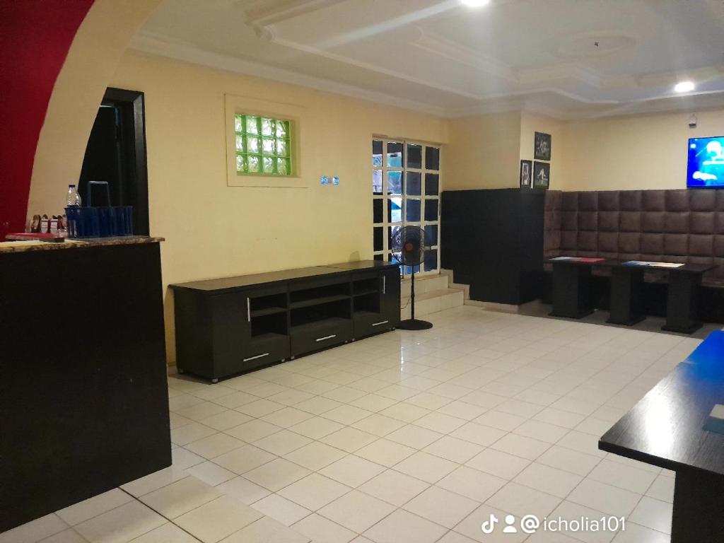 una sala de espera con una peluquería con TV en Winstons Place Hotel, en Onitsha