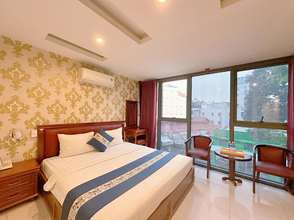 ein Schlafzimmer mit einem Bett und einem großen Fenster in der Unterkunft Kim Dung Hotel Tran Quang Khai in Ho-Chi-Minh-Stadt