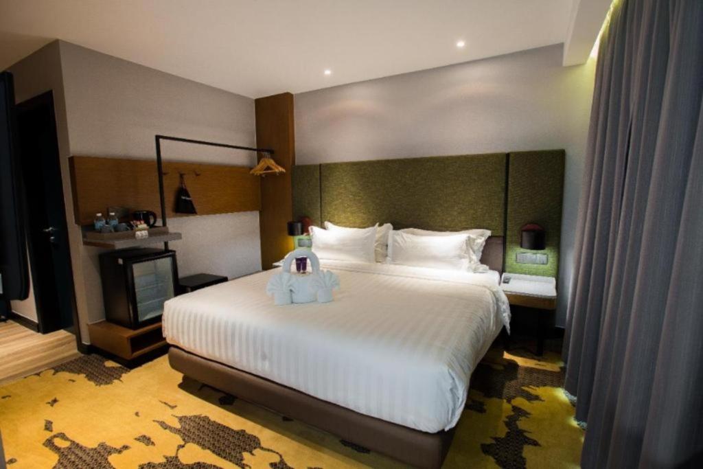 - une chambre avec un grand lit blanc dans l'établissement King Park Hotel Kota Kinabalu, à Kota Kinabalu