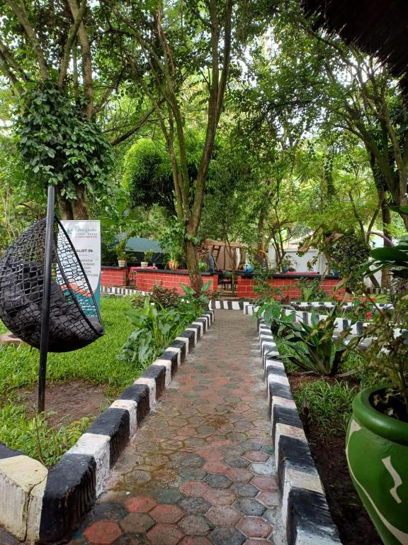 Green Garden Guest House في أروشا: ممشى في حديقة فيها مضرب تنس