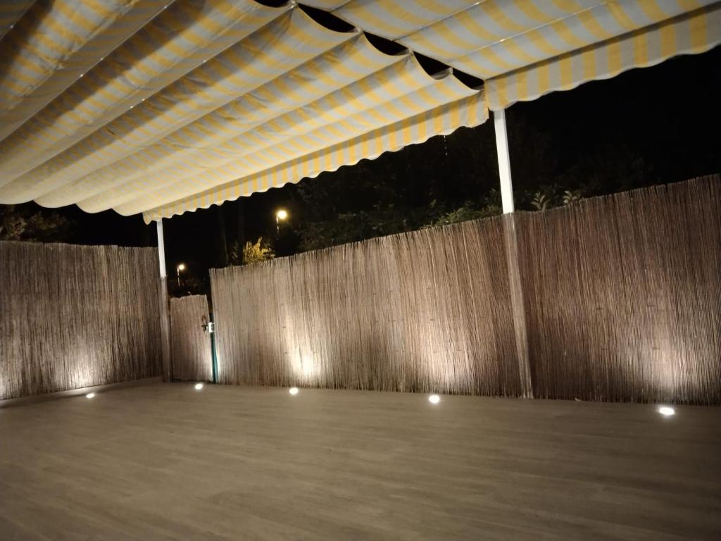 a patio with awning over a fence at night at APARTAMENTO PLANTA BAJA CANET DE BERENGUER in Canet de Berenguer