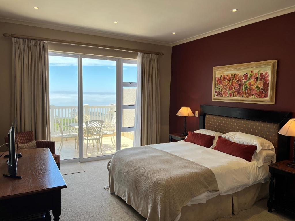 a hotel room with a bed and a large window at La Best Pinnacle Point Lodges & Villa in Mossel Bay