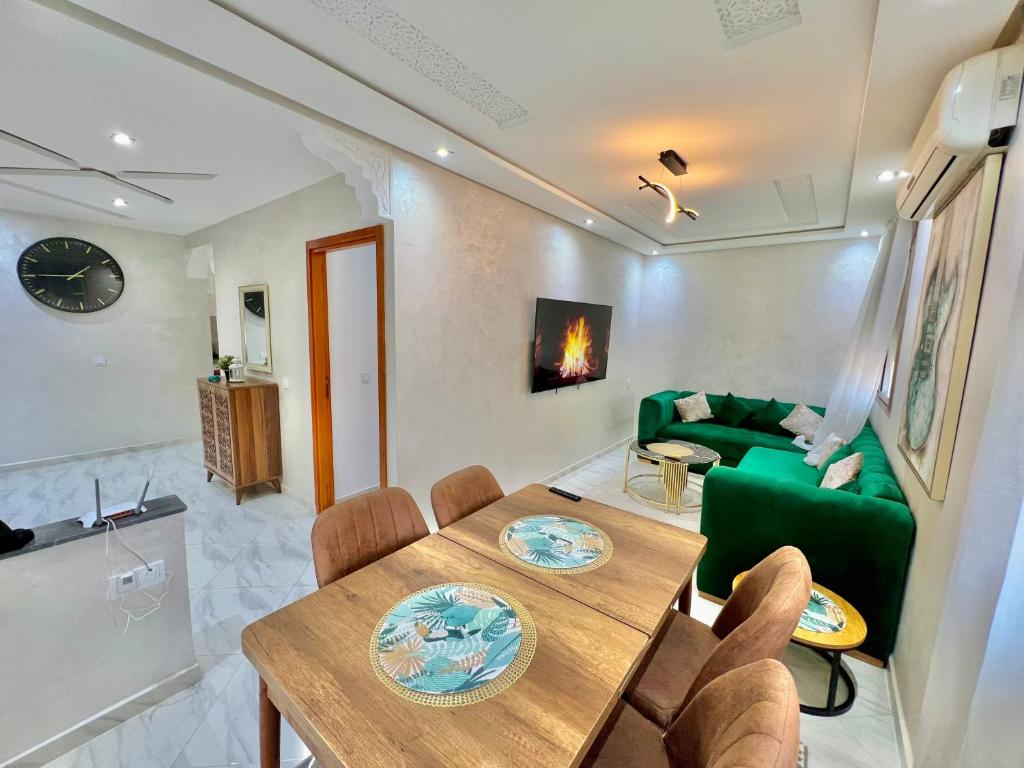 a living room with a table and a green couch at A2 Luxe Moderne et Confort, 7 min du Stade Moulay Abdellah in Temara
