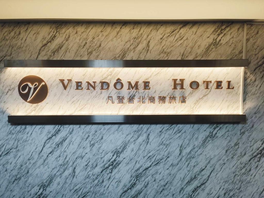 a sign for a wandone hotel on a wall at 凡登台北商務旅店 in Taipei