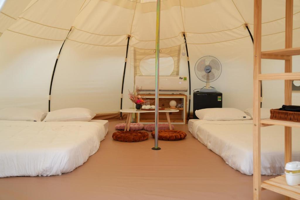 two beds in a room with a tent at Mango Beach Hotel & Camping in Ấp Khánh Phước (1)