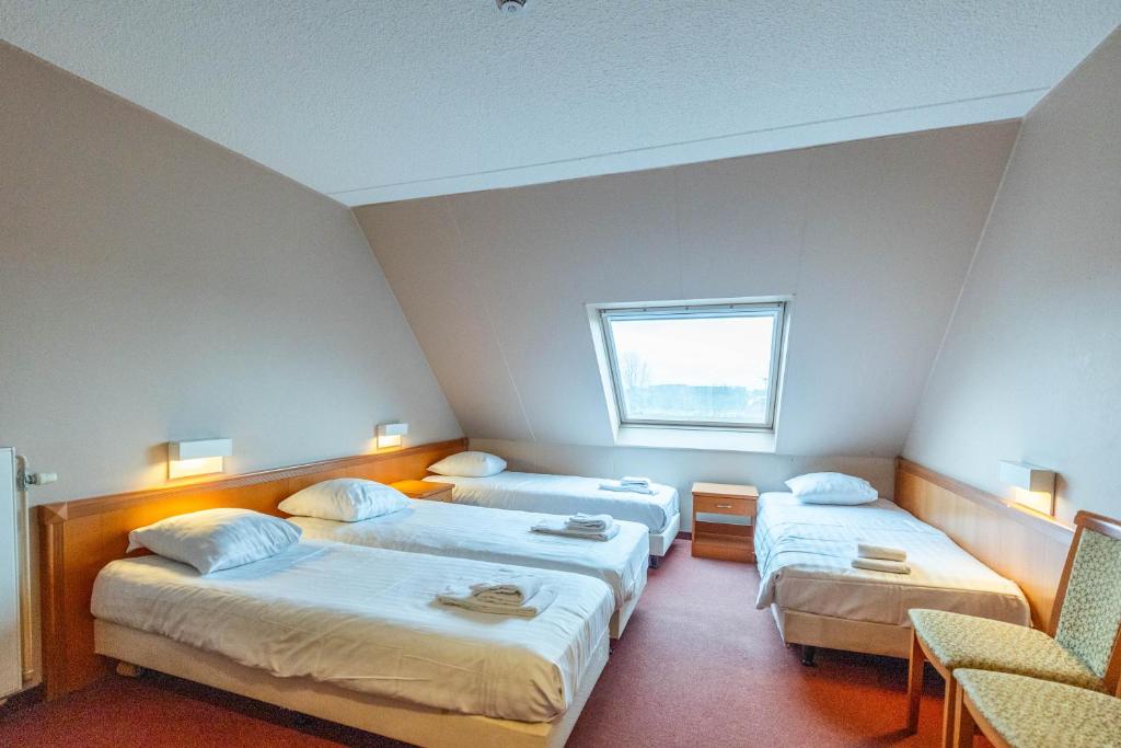 a hotel room with two beds and a window at Corsendonk Duinse Polders in Blankenberge