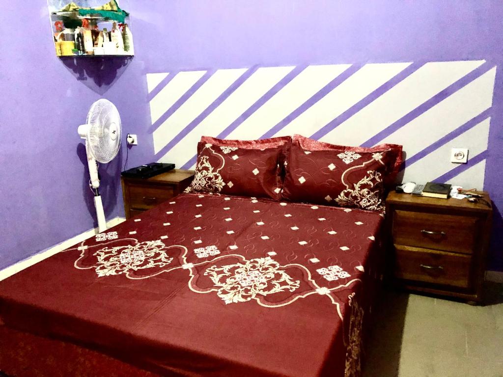 1 dormitorio con 1 cama con edredón rojo en Le Caire قاهرة, en Rufisque