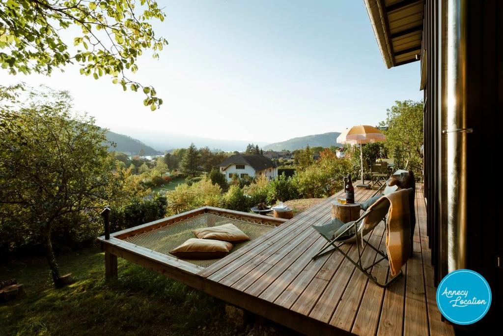 a woman sitting on a deck with a hot tub at Ecolodge Acm in Rovagny