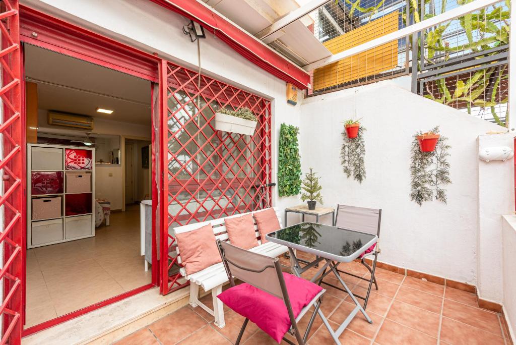a patio with a table and chairs and a building at Casita playa in Málaga