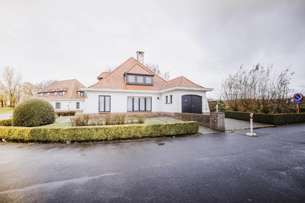 a white house with a driveway in front of it at Corsendonk Duinse Polders in Blankenberge