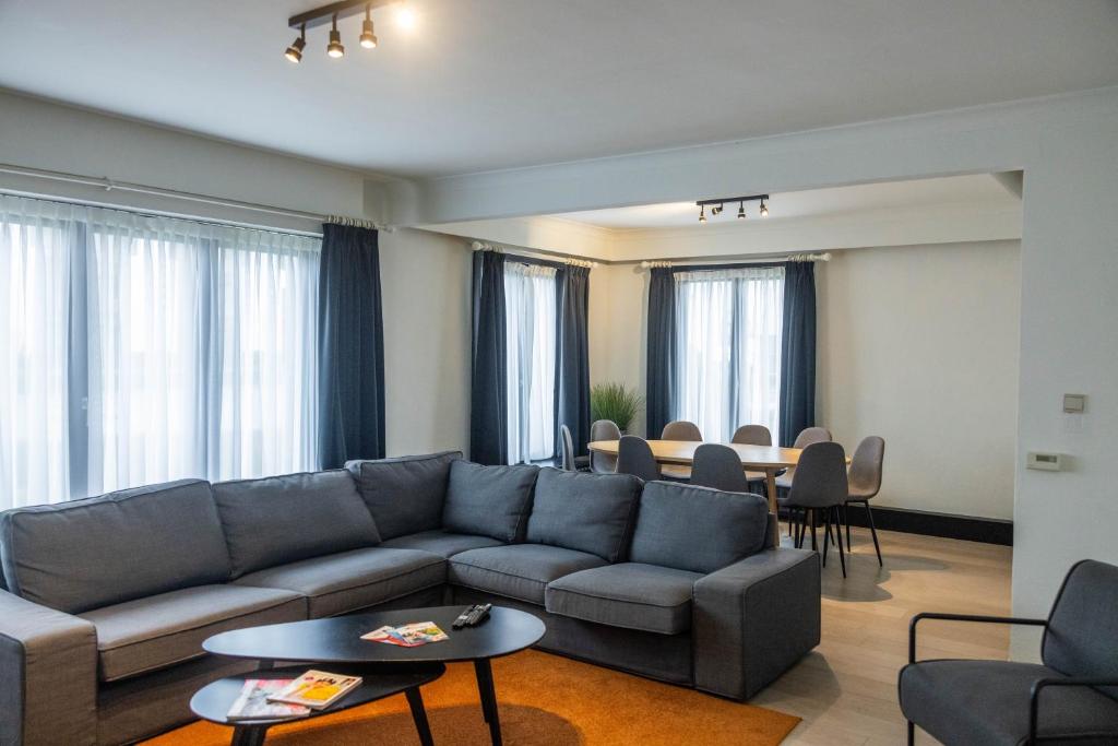 a living room with a couch and a table at Corsendonk Duinse Polders in Blankenberge