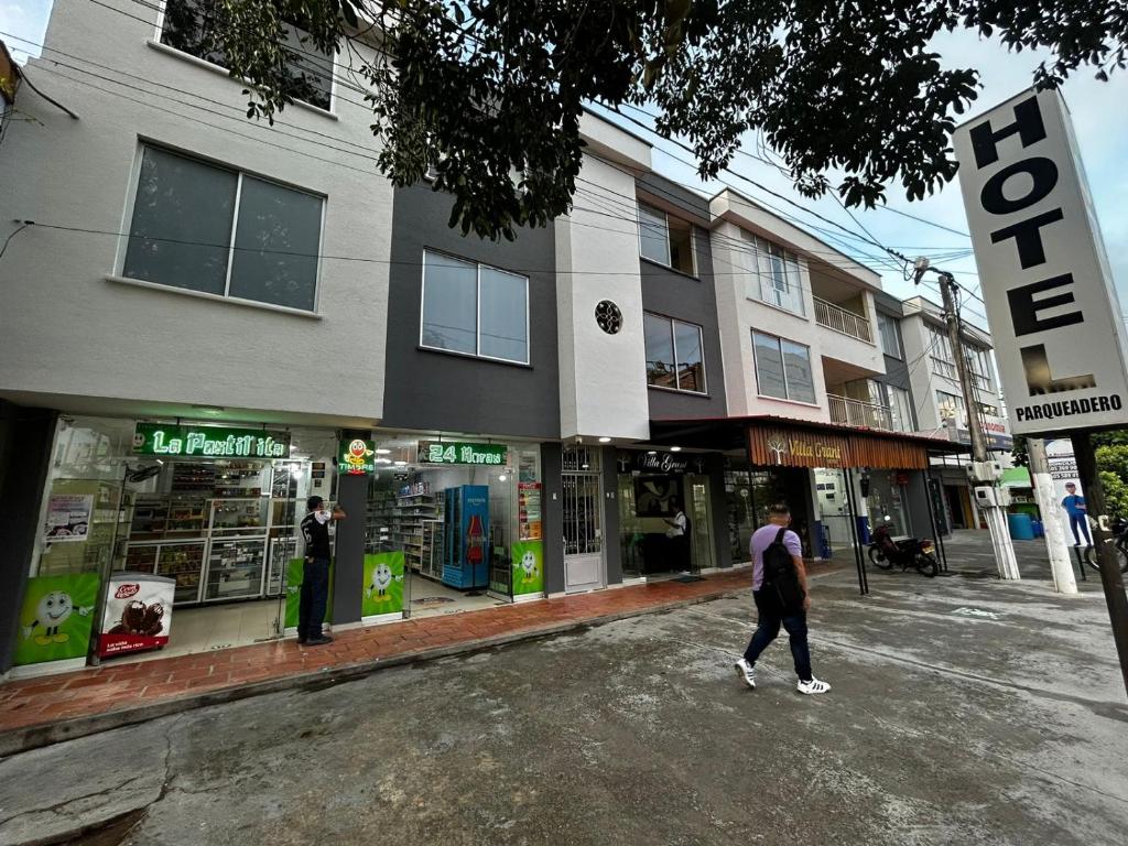una persona caminando por una calle frente a una tienda en Hotel Villa Grant, en Aguachica