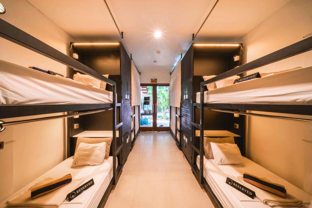 a room with four bunk beds in a room at The Farm Hostel in Canggu