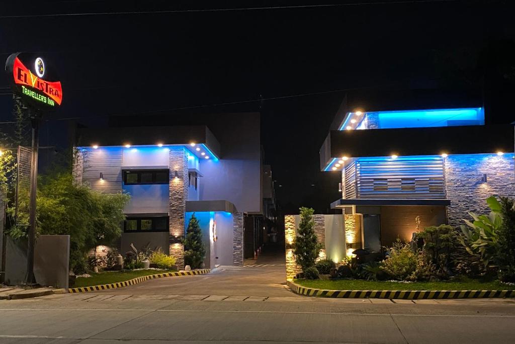 een gebouw met 's nachts blauwe lichten bij El Vistra Traveller's Inn in Calumpit