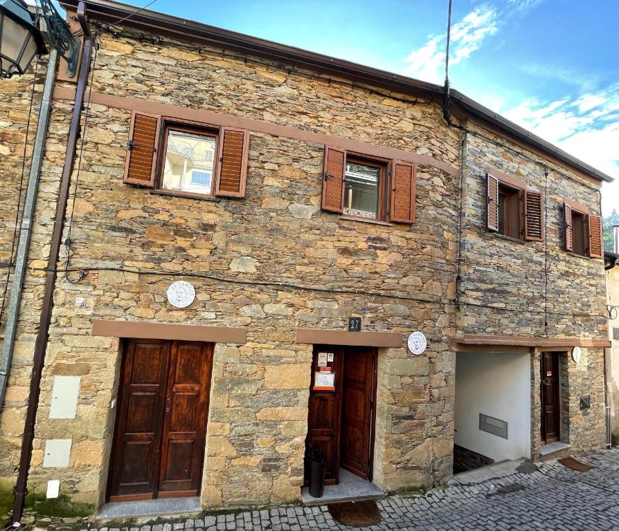 a stone building with wooden doors and windows at Alojamento Local - Casa Zé Santos - Aldeias do Xisto - Sobral de São Miguel - Covilhã in Sobral de São Miguel