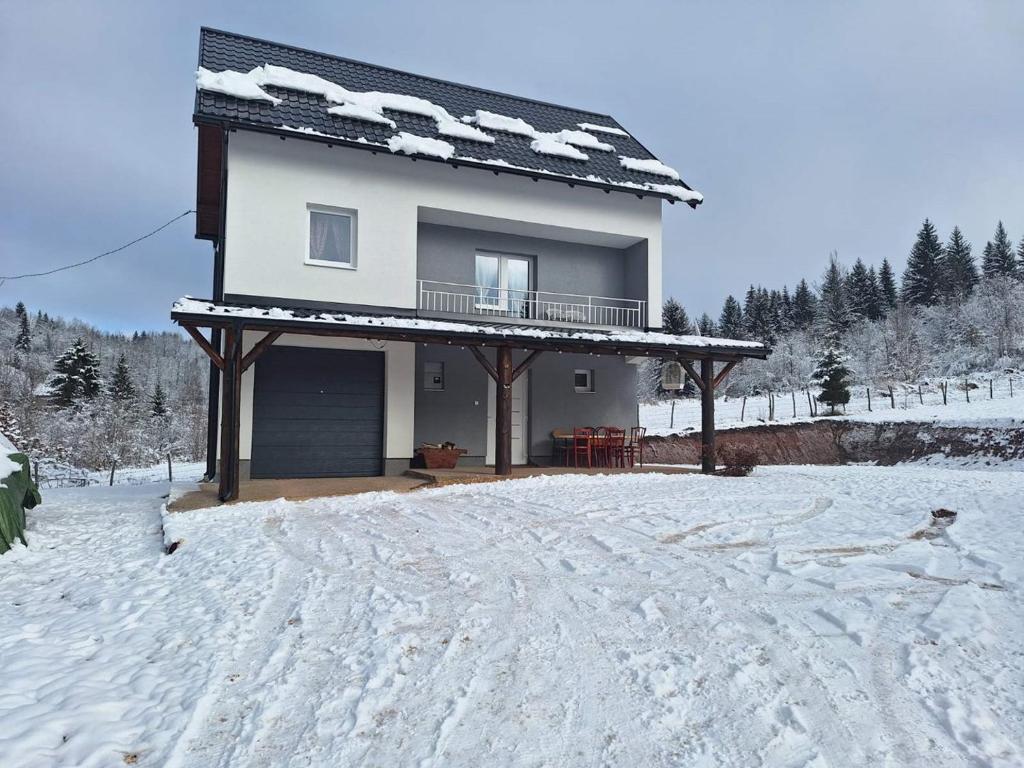 una casa con nieve en el suelo delante de ella en Holiday Home Mali Raj, en Pale