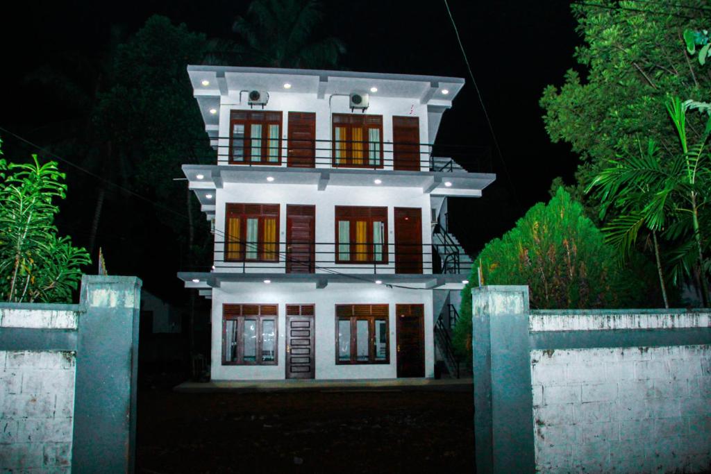 une maison blanche la nuit avec ses lumières allumées dans l'établissement Saimon Villa, à Mirissa