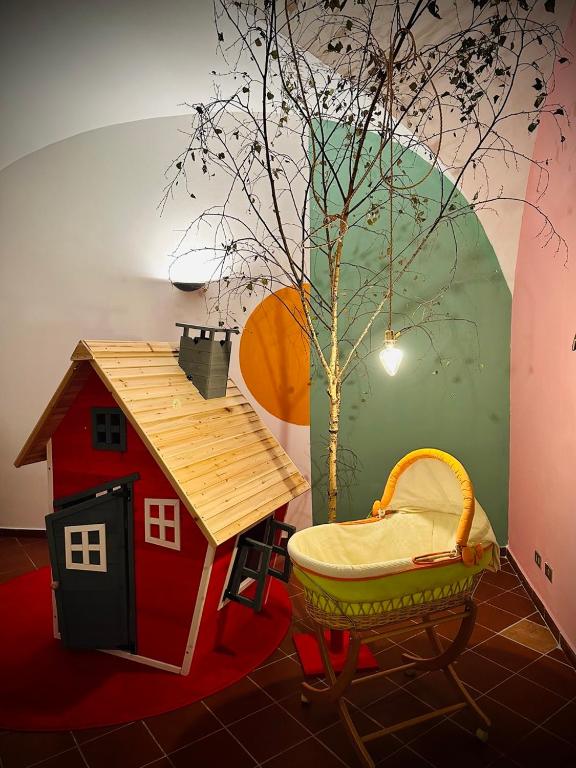 uma sala de jogos com uma casa de brinquedos e uma árvore em WOW HOUSE in Torino em Turim
