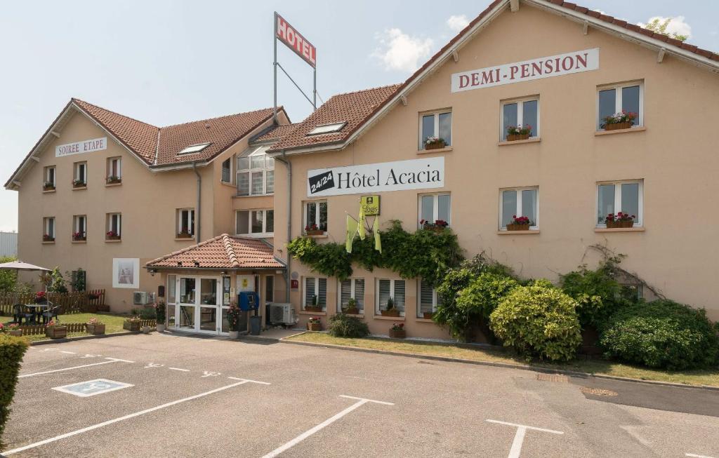 un hotel con un estacionamiento delante de él en Hôtel Acacia Nancy sud Lunéville, en Lunéville