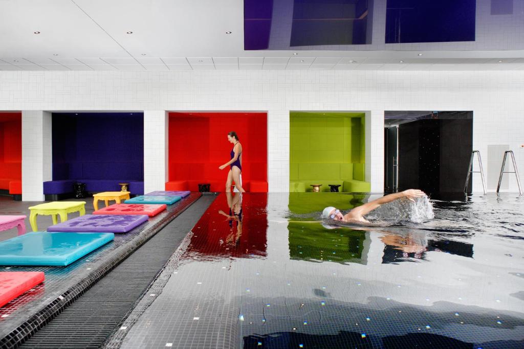 een groep mensen die zwemmen in een zwembad bij Crowne Plaza Antwerpen, an IHG Hotel in Antwerpen