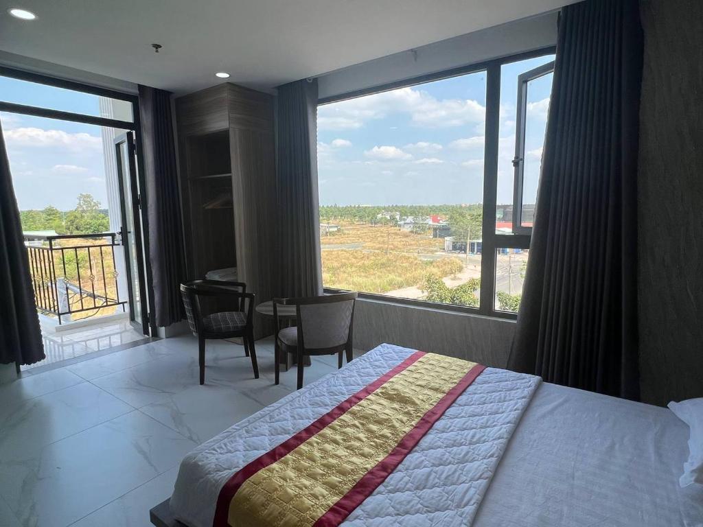 a hotel room with a bed and a large window at Hotel Stylish Tân Khai in Hớn Quản