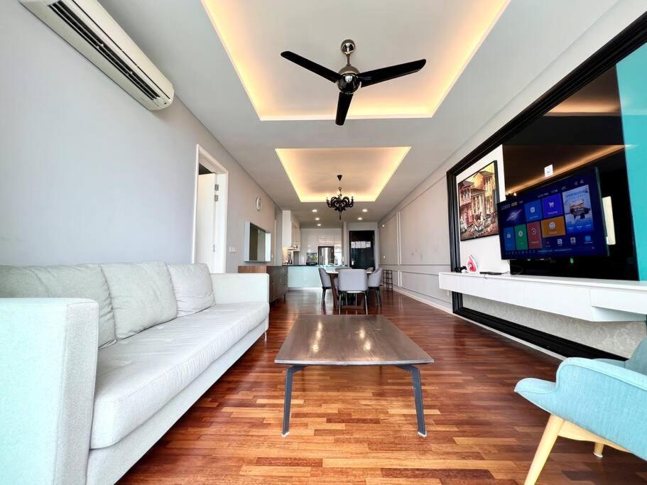 sala de estar con sofá blanco y TV de pantalla plana en The Shore River Condo 3BR/7pax/Wi-fi/6minDr2jonker, en Melaka
