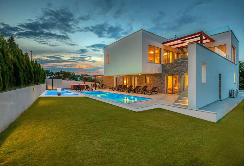 una casa con piscina en el patio trasero en 5 Sterne Villa am Meer mit 2 Pools Leon'sHolidayHomes, en Pula