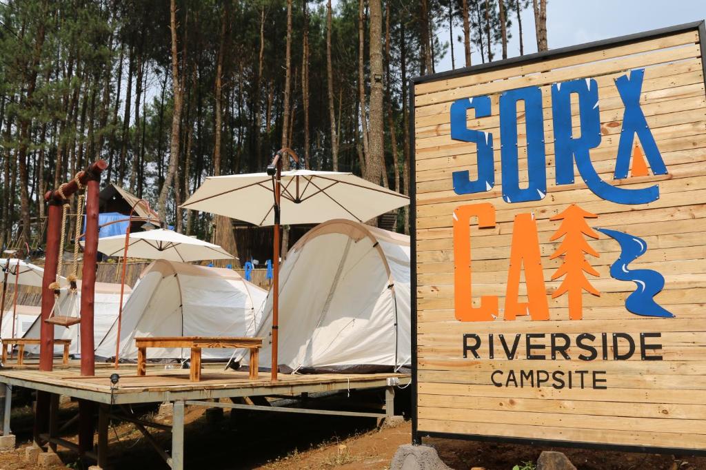 ein Schild mit zwei Zelten und einem Schild für einen Campingplatz in der Unterkunft SoraCai Riverside Campsite in Palayangan