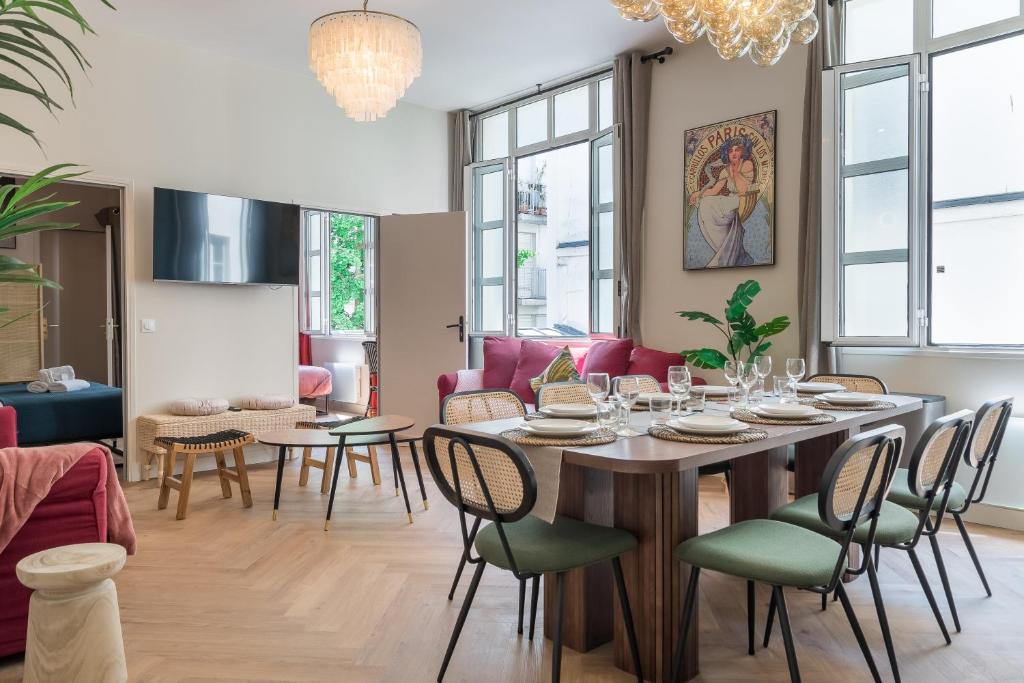 a dining room and living room with a table and chairs at Sophie Stay - Le Mucha - King size bed - AC in Paris