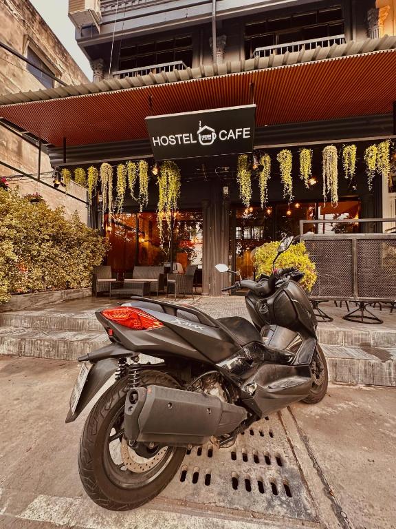 una moto parcheggiata di fronte a un edificio di Hostel Friends Station & Cafe a Pattaya Sud