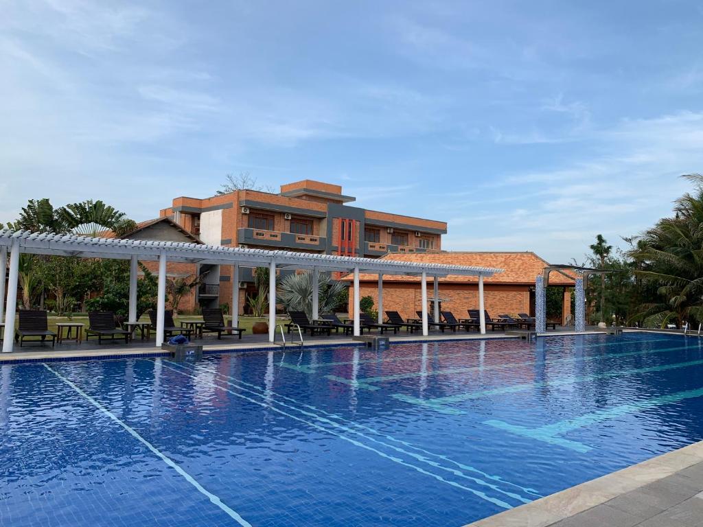 a swimming pool in front of a building at Blue Shell Resort in Mui Ne