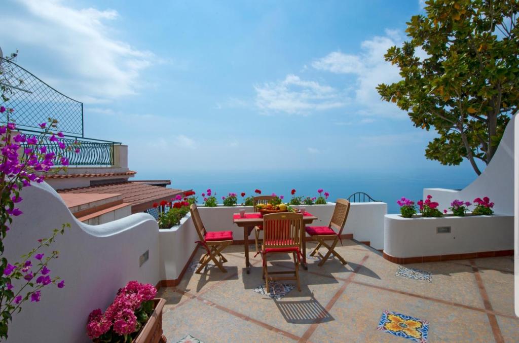 patio ze stołem i krzesłami oraz oceanem w obiekcie Holidays dream Praiano w mieście Praiano