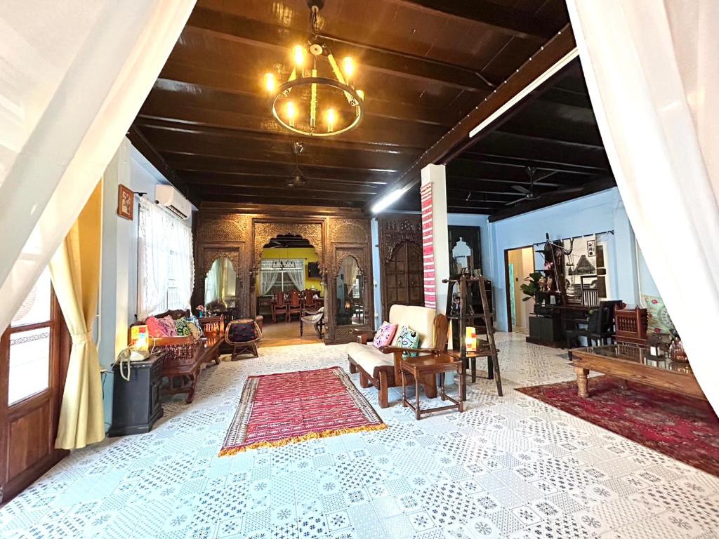 sala de estar amplia con lámpara de araña y alfombra en บ้านมาดามกรีน Baan Madamn Green Nan, en Nan