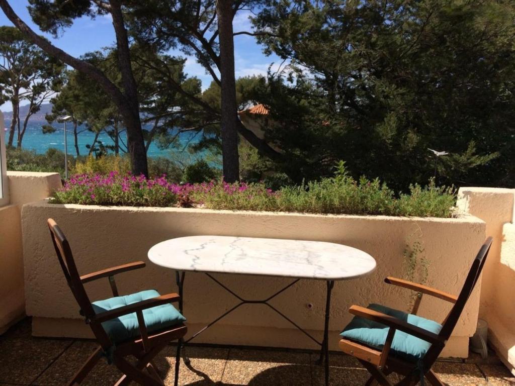 Una mesa y sillas en un patio con vista al mar. en Appartement vue mer à La Madrague, en Saint-Cyr-sur-Mer
