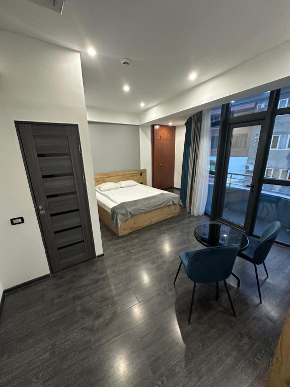 een slaapkamer met een bed, een bureau en een tafel bij ABC HOTEL in Jerevan