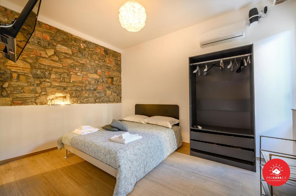 una camera con letto e parete in pietra di Helios a La Spezia
