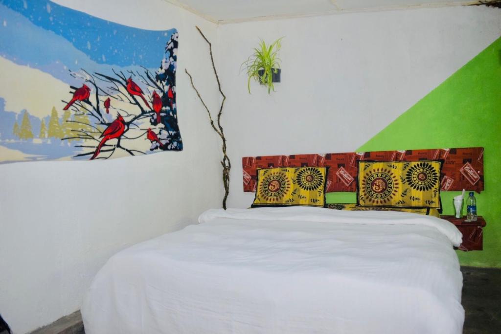 una camera con un letto bianco e un dipinto sul muro di Pedro home stay a Nuwara Eliya