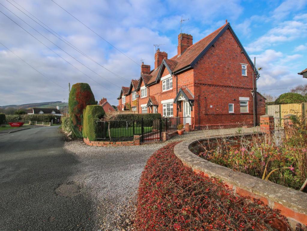 uma grande casa de tijolos vermelhos no lado de uma estrada em 8 New Houses em Wrexham