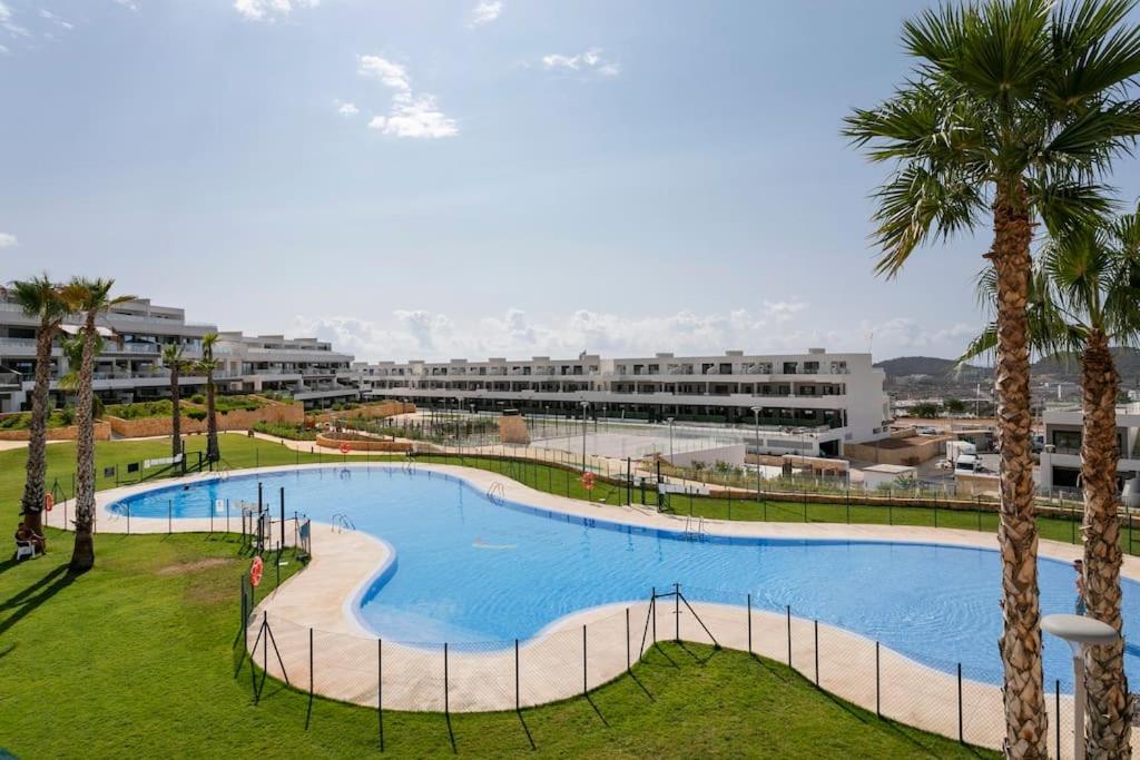 une grande piscine dans un parc planté de palmiers dans l'établissement Fabulous apartment in new complex, à Finestrat