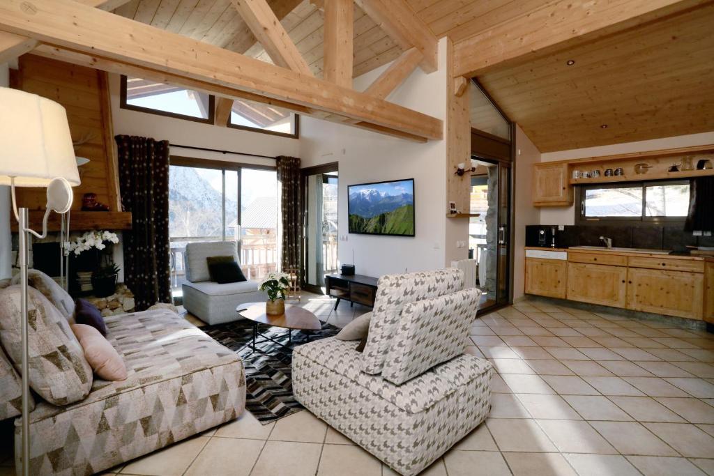 ein großes Wohnzimmer mit einem Sofa und Stühlen in der Unterkunft Swan 3 - Appartement 6 couchages in Les Deux Alpes