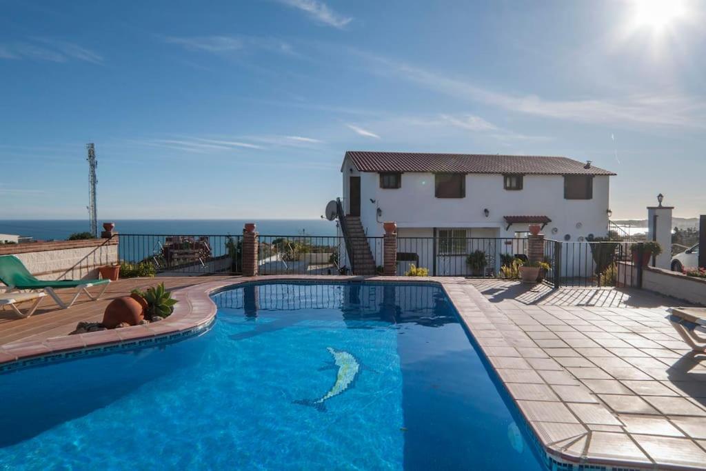 a swimming pool in front of a house at Casa rural junto al mar in Benalmádena