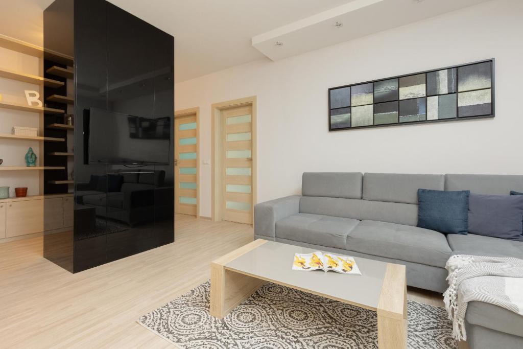 a living room with a couch and a coffee table at Woronicza Apartment with Balcony In Warsaw's Mokotów by Renters in Warsaw