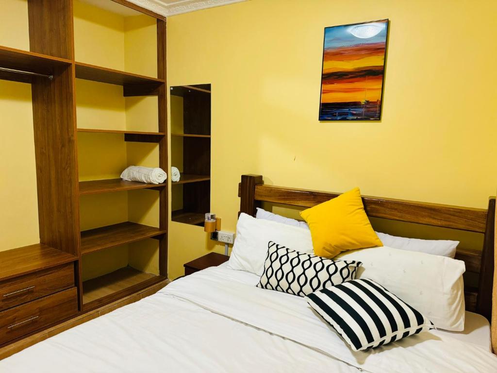 - une chambre avec un lit doté de draps et d'oreillers blancs dans l'établissement Lovely 2 Bedroom Apartment in Ongata Rongai, à Langata Rongai