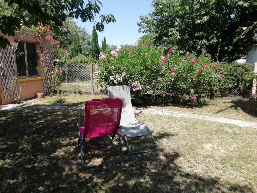 una silla roja sentada en el césped en un patio en chez Patrice et Gilda, en Albi